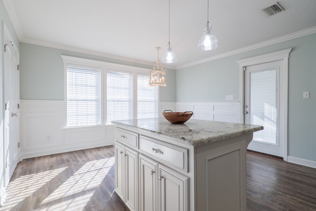 kitchen with dark hardwood / wood-style flooring, a center island, ornamental molding, and a healthy amount of sunlight