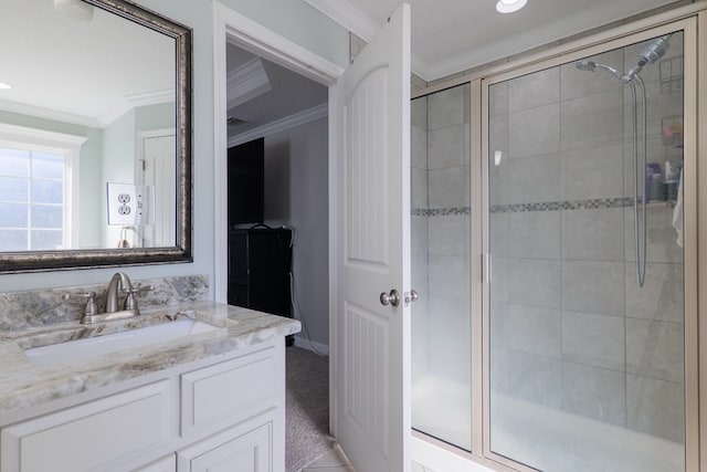 bathroom with vanity, a shower with door, and crown molding