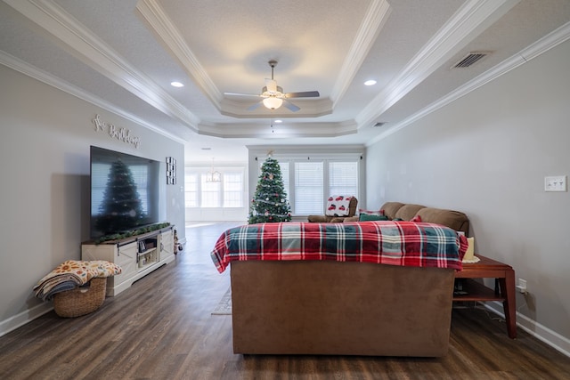 bedroom with dark hardwood / wood-style floors, a tray ceiling, and crown molding