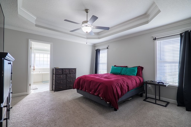 carpeted bedroom with ceiling fan, crown molding, connected bathroom, and a tray ceiling