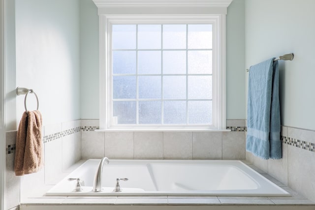 bathroom with a relaxing tiled tub