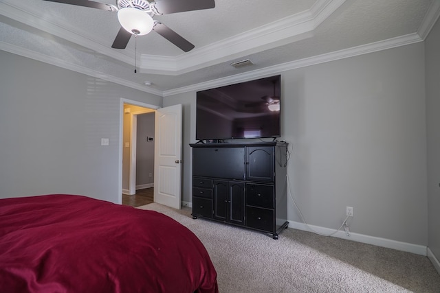 bedroom featuring a raised ceiling, ceiling fan, light colored carpet, and ornamental molding