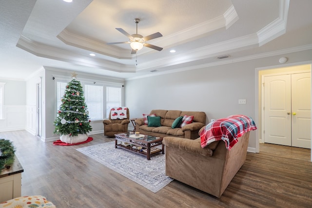 living room featuring a raised ceiling and ornamental molding