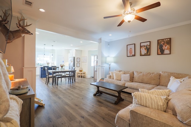 living area featuring recessed lighting, visible vents, wood finished floors, and ornamental molding