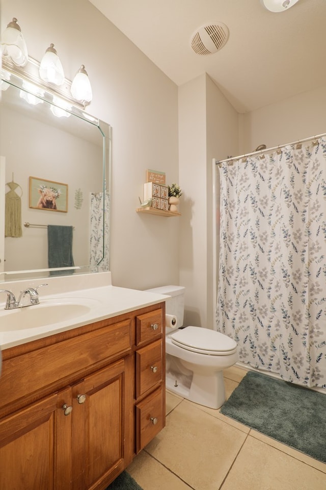 bathroom with tile patterned flooring, vanity, and toilet