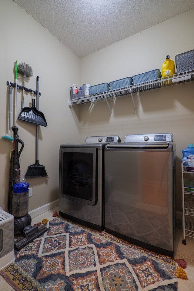 washroom with a textured ceiling and separate washer and dryer