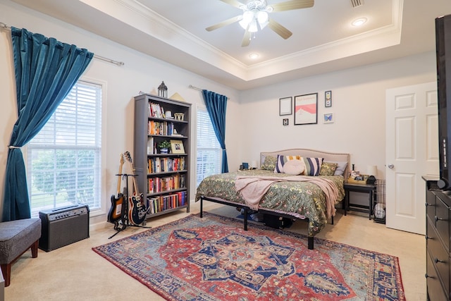 carpeted bedroom with a raised ceiling, ceiling fan, and ornamental molding