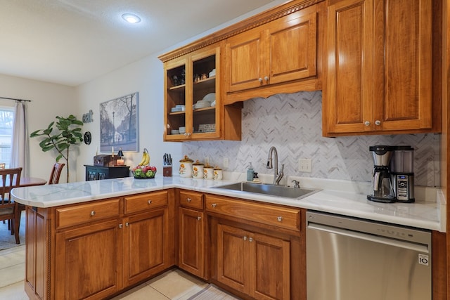 kitchen featuring stainless steel dishwasher, light tile patterned flooring, kitchen peninsula, and sink