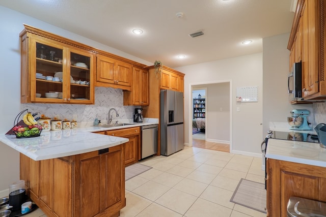 kitchen with decorative backsplash, light tile patterned flooring, sink, and stainless steel appliances