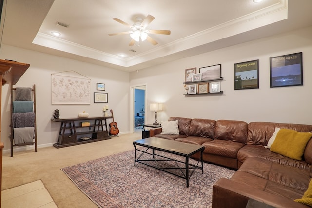 carpeted living room with ceiling fan, a raised ceiling, and crown molding