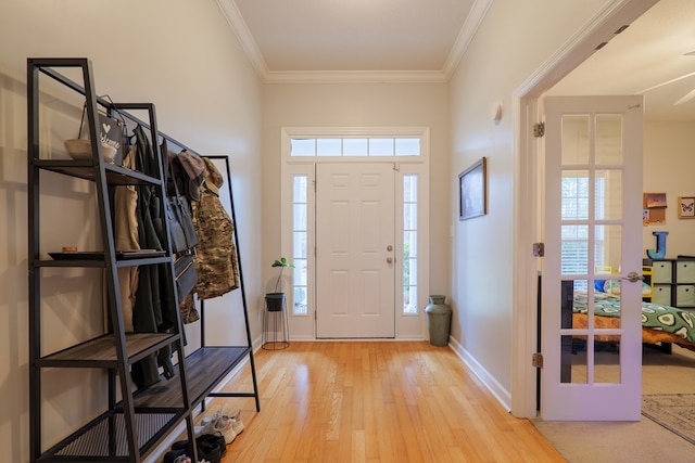 entrance foyer with crown molding, plenty of natural light, and light wood-type flooring