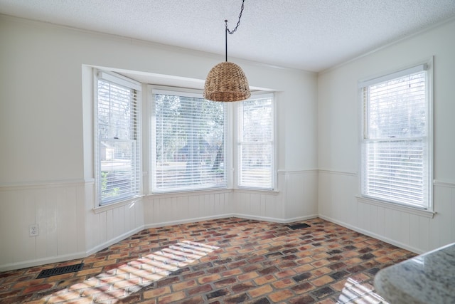 dining area with brick floor, plenty of natural light, and wainscoting