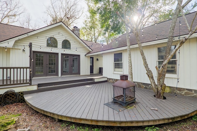 wooden terrace featuring a fire pit and french doors