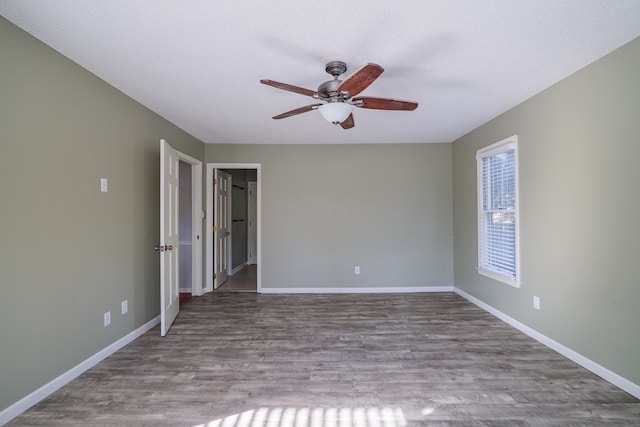 unfurnished room featuring ceiling fan, light wood finished floors, a textured ceiling, and baseboards