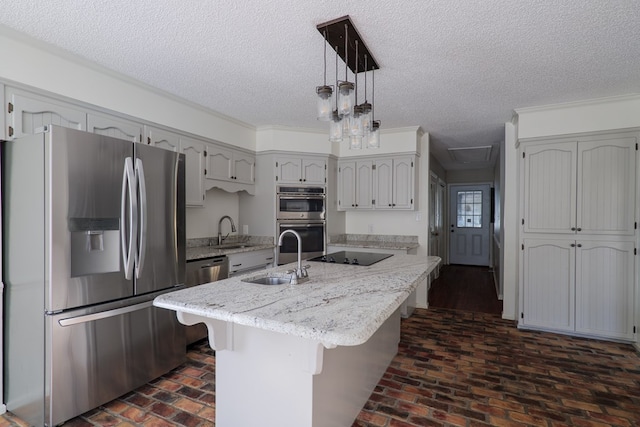 kitchen featuring a center island with sink, appliances with stainless steel finishes, a kitchen breakfast bar, hanging light fixtures, and a sink