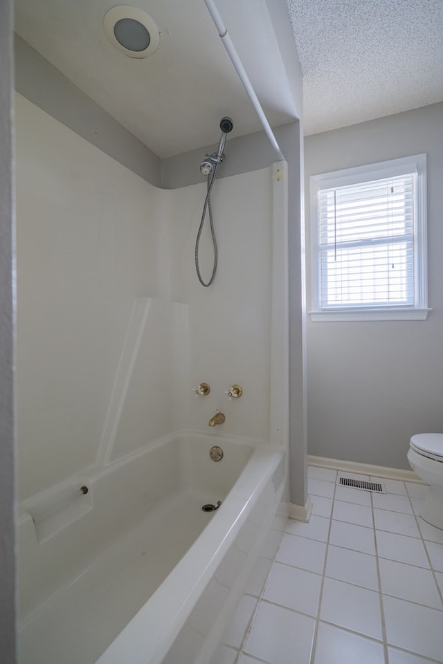 full bathroom featuring shower / washtub combination, visible vents, toilet, a textured ceiling, and tile patterned flooring