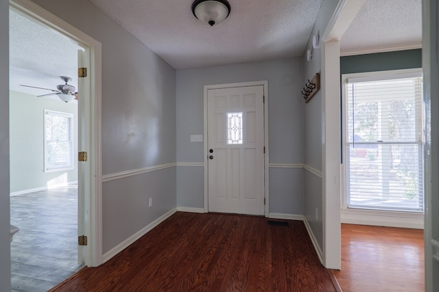 entrance foyer featuring dark wood-type flooring, a textured ceiling, and baseboards