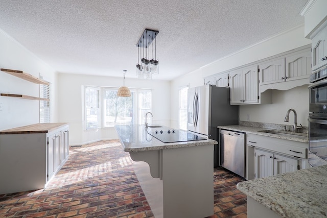 kitchen featuring brick floor, stainless steel appliances, a sink, a center island, and pendant lighting