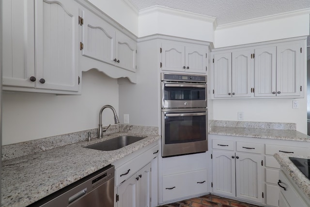 kitchen with crown molding, white cabinetry, stainless steel appliances, and a sink