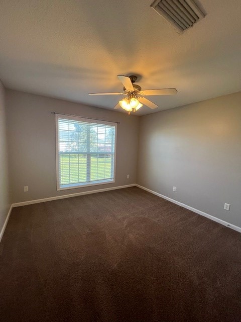 3664 Druid Oaks Dr, Valdosta, GA 31602 - spare room featuring visible vents, dark carpet, baseboards, and a ceiling fan