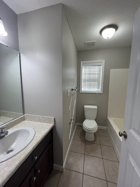 3664 Druid Oaks Dr, Valdosta, GA 31602 - full bathroom with tile patterned floors, toilet, a washtub, a textured ceiling, and vanity