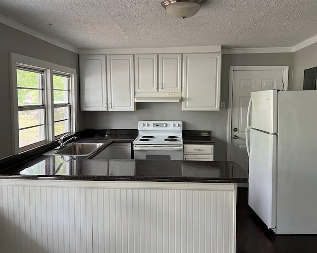 kitchen with white cabinets, sink, white appliances, and kitchen peninsula