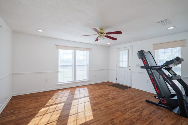 exercise area with recessed lighting, plenty of natural light, wood finished floors, and visible vents