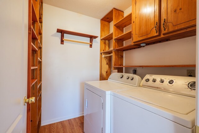 laundry area with light wood-style floors, baseboards, separate washer and dryer, and cabinet space