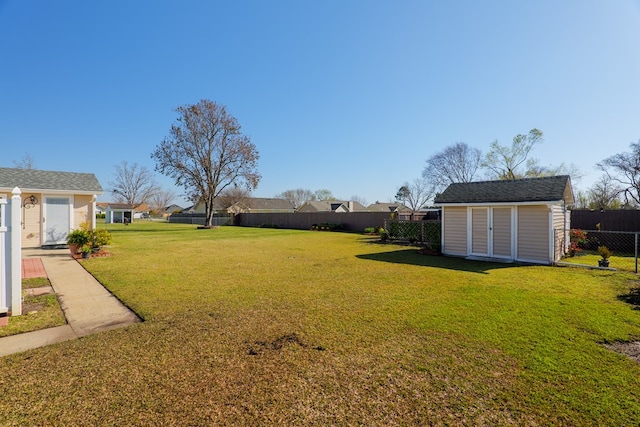 view of yard with a shed, an outdoor structure, and a fenced backyard