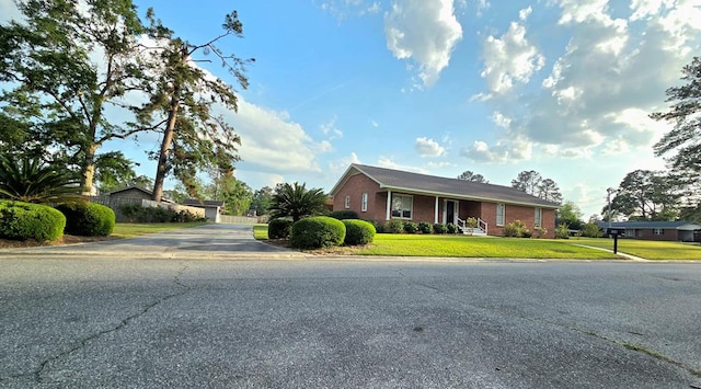 single story home with brick siding and a front lawn