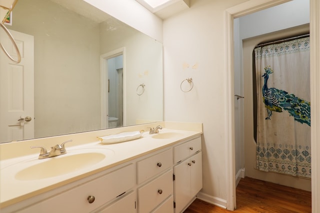 bathroom with curtained shower, vanity, wood-type flooring, and toilet