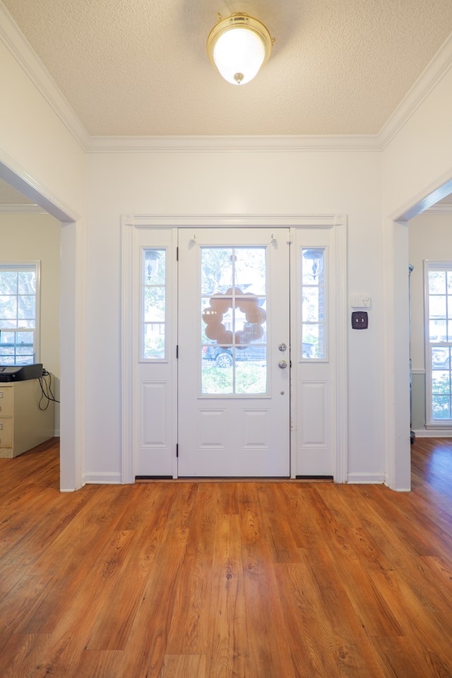 foyer entrance with hardwood / wood-style floors, a healthy amount of sunlight, and a textured ceiling