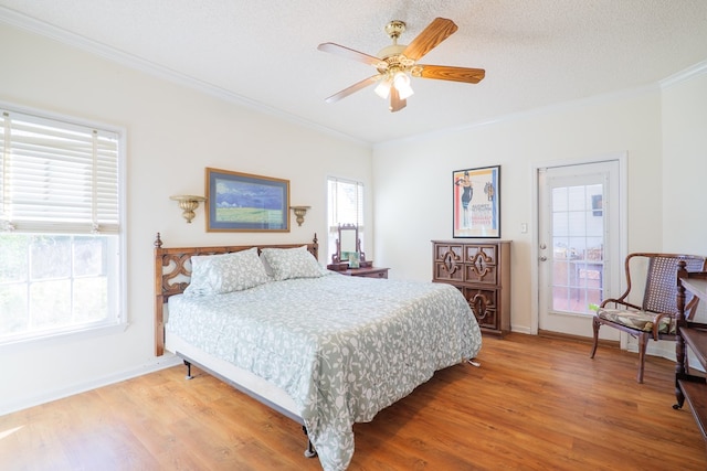 bedroom featuring hardwood / wood-style floors, ceiling fan, ornamental molding, and a textured ceiling