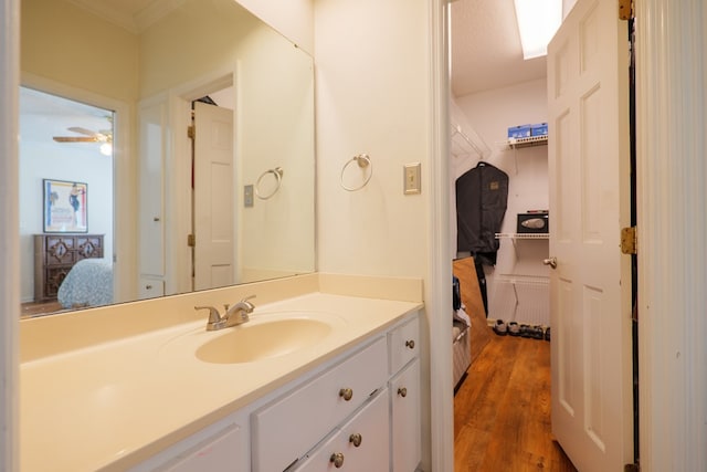 bathroom with vanity, crown molding, hardwood / wood-style flooring, ceiling fan, and a textured ceiling