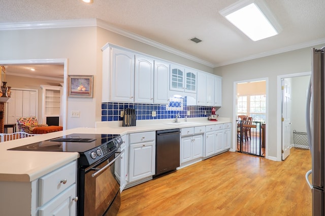 kitchen featuring a textured ceiling, stainless steel appliances, crown molding, white cabinets, and light hardwood / wood-style floors