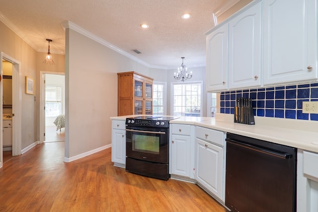 kitchen featuring ornamental molding, a textured ceiling, black appliances, pendant lighting, and white cabinets