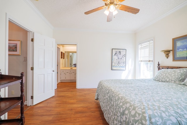 bedroom with wood-type flooring, a textured ceiling, ensuite bath, and ceiling fan