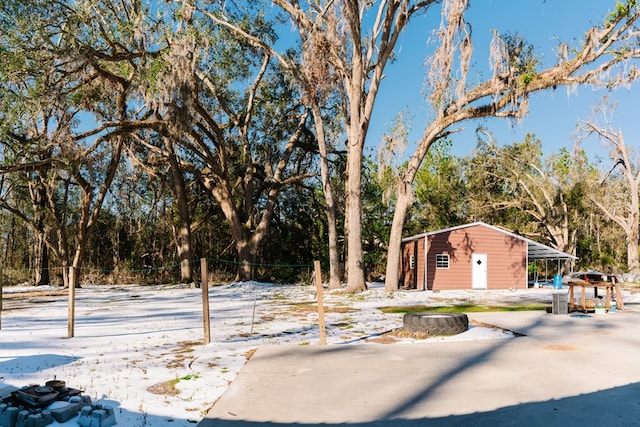 snowy yard featuring an outbuilding