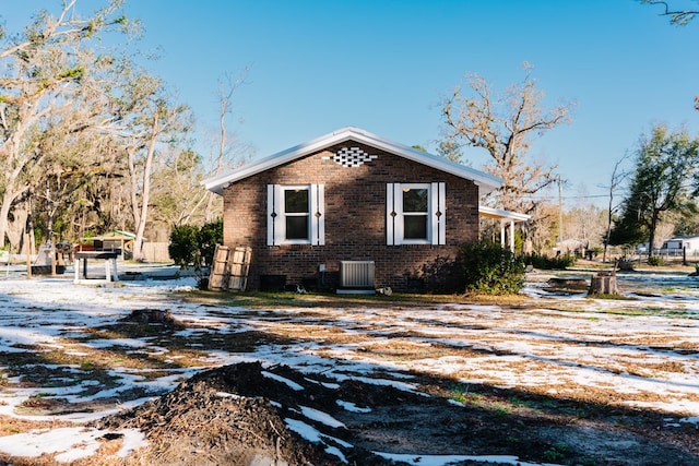 view of snowy exterior with brick siding