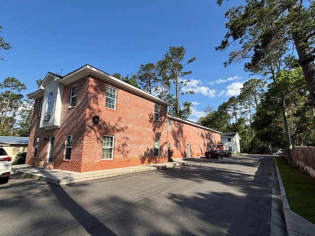view of home's exterior featuring brick siding and fence