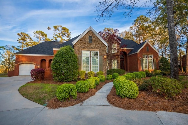 view of front of house with stone siding, driveway, and a garage
