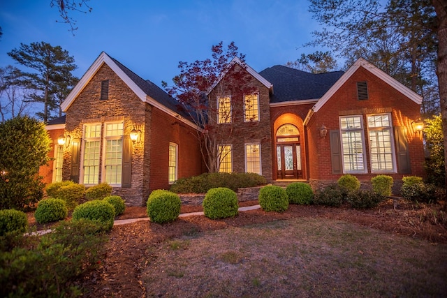 traditional home with stone siding and brick siding