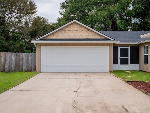 ranch-style house featuring a garage, fence, concrete driveway, roof with shingles, and a front lawn