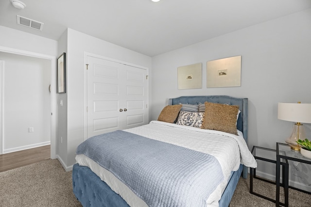 bedroom with carpet floors, a closet, visible vents, and baseboards