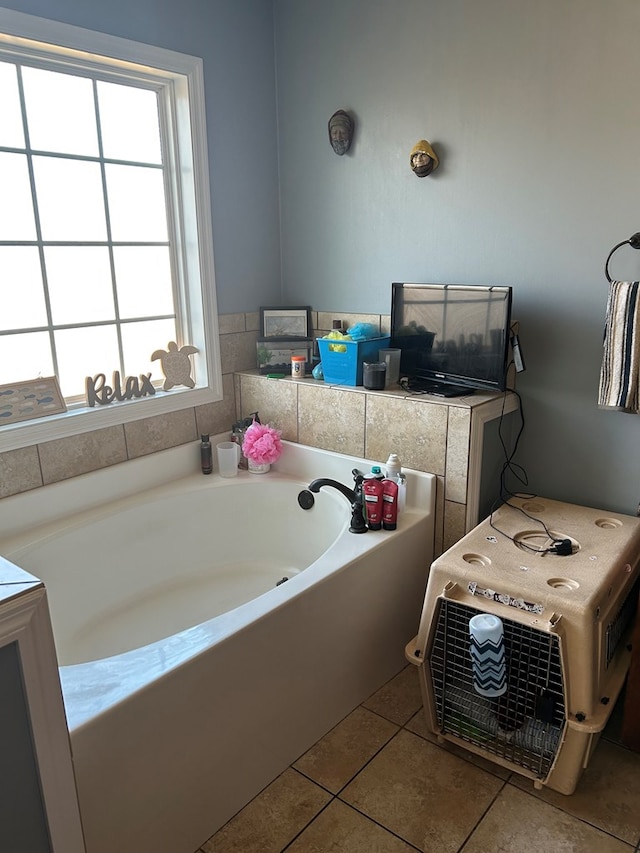 bathroom with tile patterned flooring and a tub