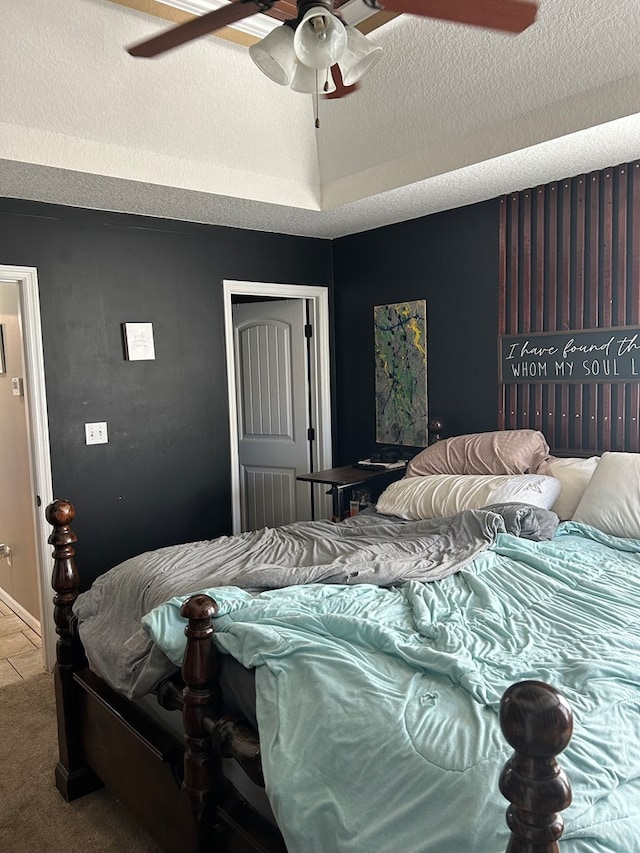 bedroom with ceiling fan, carpet floors, and a textured ceiling