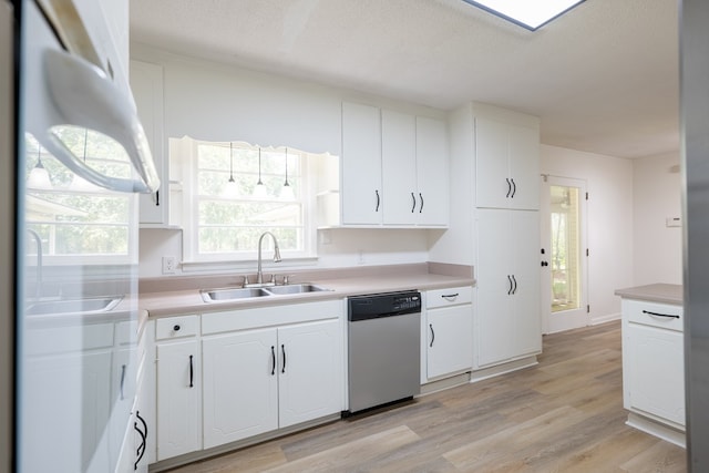 kitchen with stainless steel dishwasher, a textured ceiling, sink, white cabinets, and light hardwood / wood-style floors