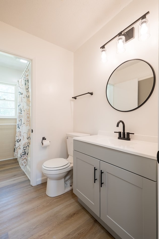 bathroom with curtained shower, hardwood / wood-style floors, vanity, and toilet