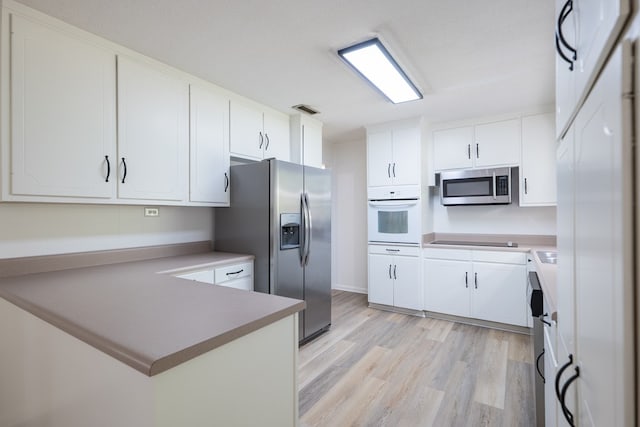 kitchen with white cabinetry, light hardwood / wood-style floors, and appliances with stainless steel finishes