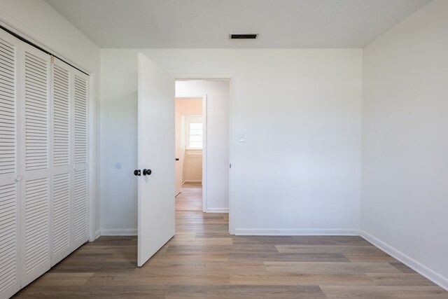 unfurnished bedroom featuring light hardwood / wood-style floors and a closet